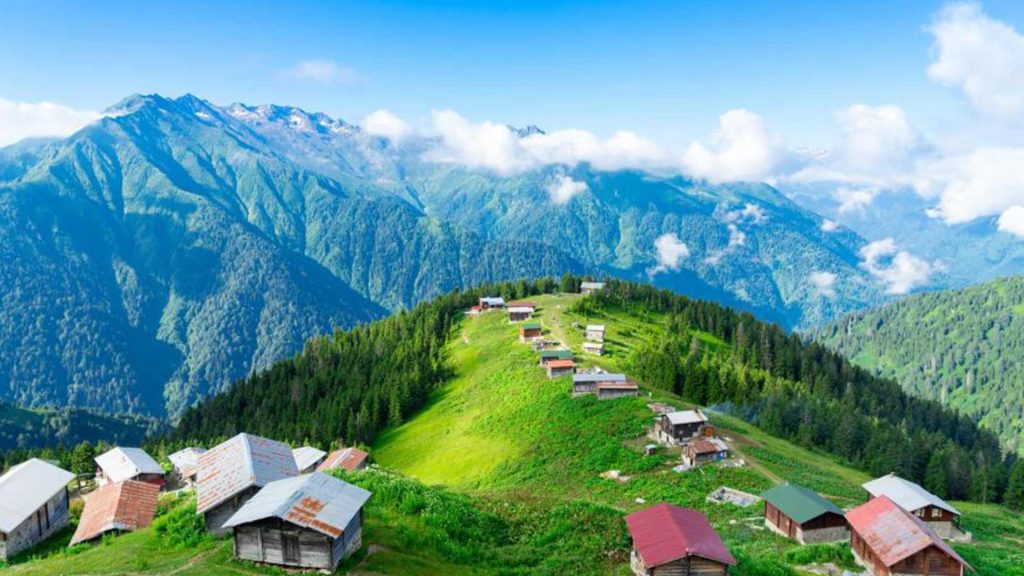 Karadeniz yaylasında doğa manzarası, yeşil tepeler ve ahşap evler